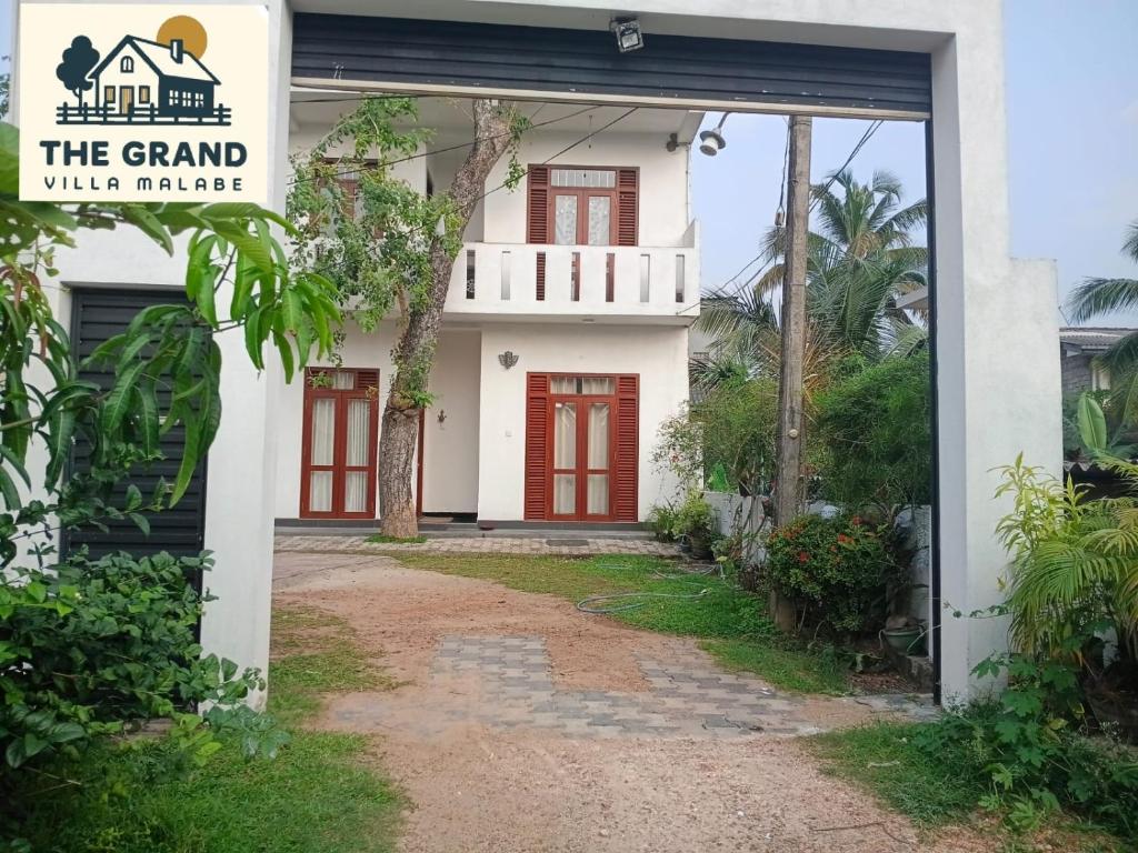 een huis met een rode deur en de grote villa bij The Grand Villa Malabe in Malabe