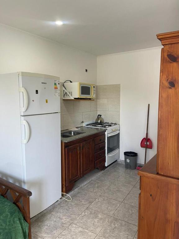a kitchen with a white refrigerator and a microwave at Departamentos Los Manantiales in Villa Gesell