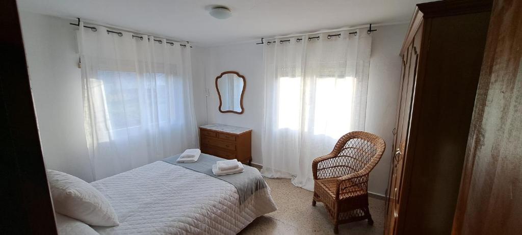 ein Schlafzimmer mit einem Bett, einem Stuhl und einem Spiegel in der Unterkunft Casa América in Labra