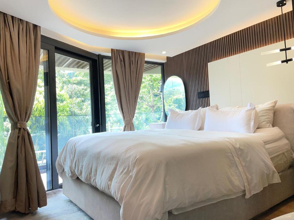 a bedroom with a large bed with a large window at Vita Resort Golf Bastos in Yaoundé