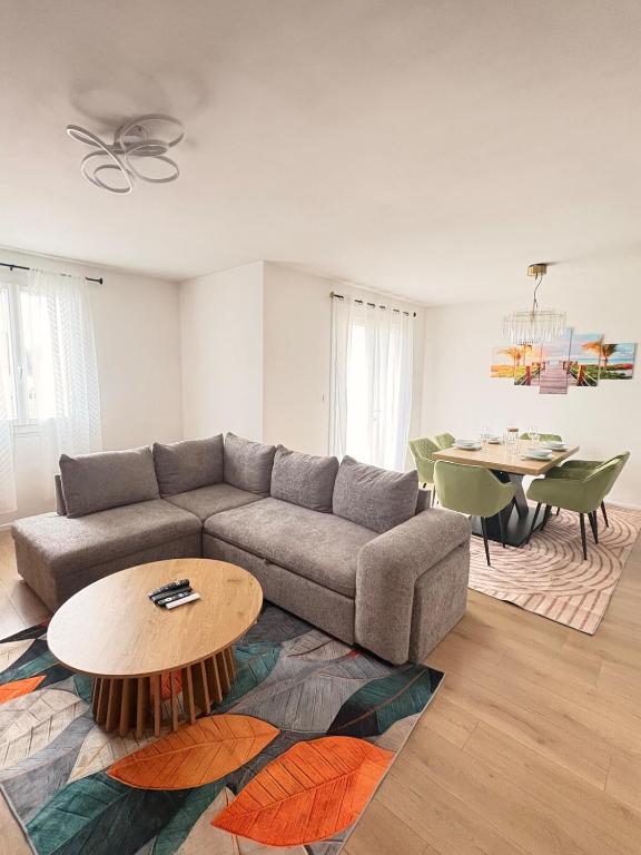 a living room with a couch and a table at Le cocon auvergnat in Lapalisse