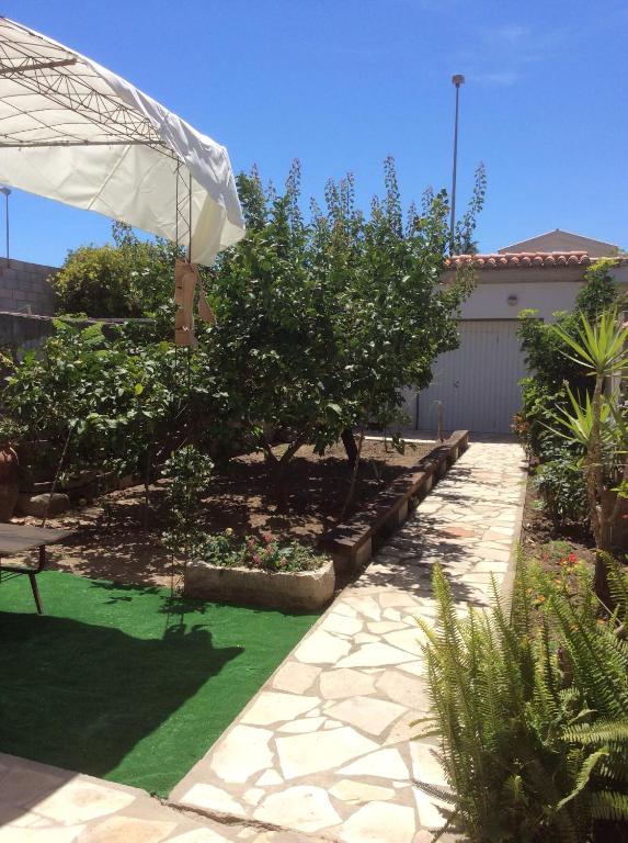 a garden with an umbrella and green grass at Ca Bienvenida in Miramar