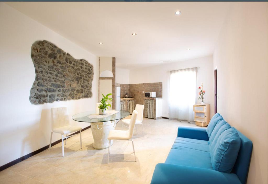 een woonkamer met een blauwe bank en een tafel bij Tourist Apartment Anna in Bracciano
