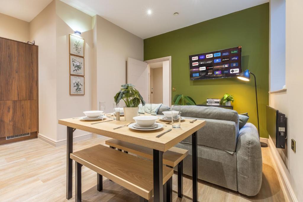 een woonkamer met een tafel en een bank bij Leeds City Centre Luxe Flats 8 mins to Station! in Central Station