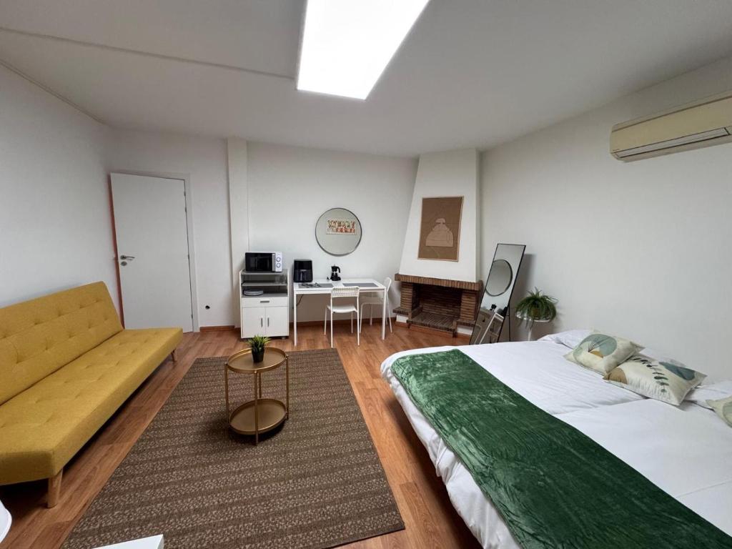 a bedroom with a large bed and a couch at Estudio Las Rozas de Madrid in Las Rozas de Madrid