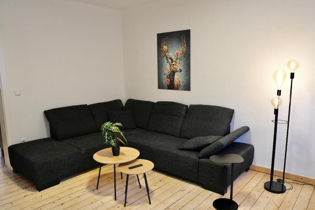 ein Wohnzimmer mit einer schwarzen Couch und einem Tisch in der Unterkunft Altstadt Apartment Deluxe 2 in Haltern