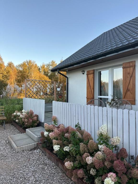 una recinzione di fronte a una casa con fiori di Międzyleś 68 