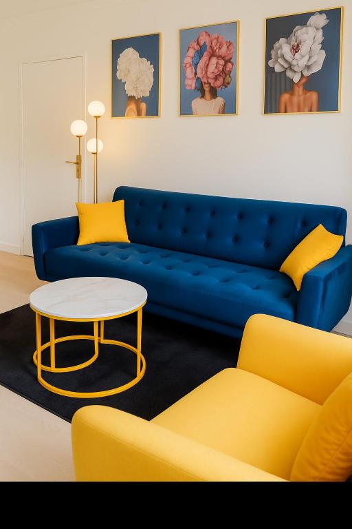 a living room with a blue couch and a table at Résidence Peace in Le Bourget