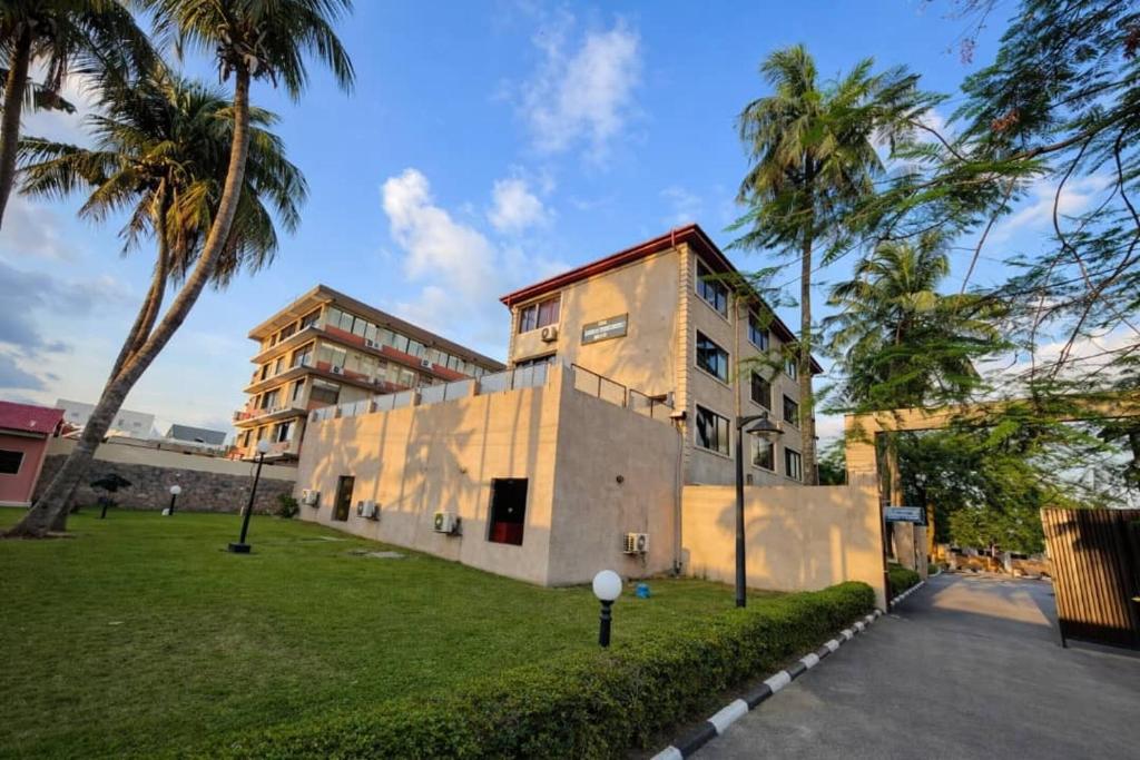 a building with palm trees in front of a building at Li Tour International Hotel in Ikeja