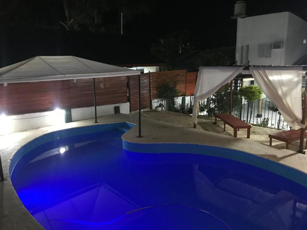 a blue swimming pool at night with a tent at Alojamiento La Mamu 1 in Paso de la Patria