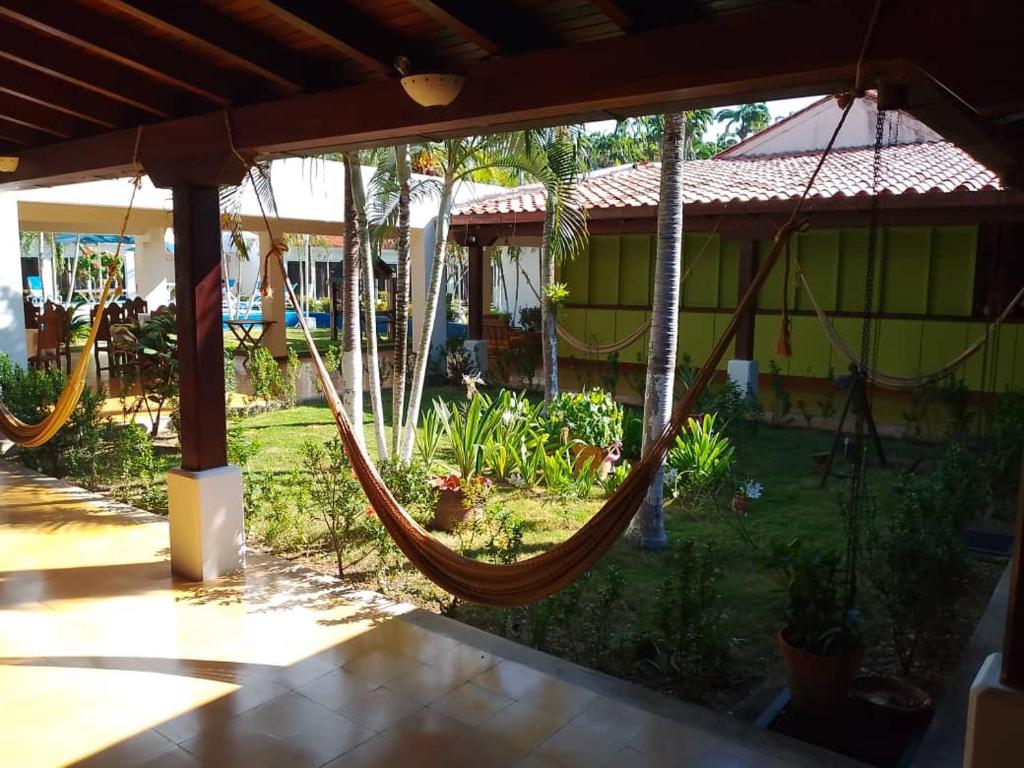 a hammock in a yard with a house at Hotel Saylu by Venetur in Río Caribe