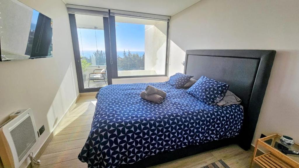 Un dormitorio con una cama y una ventana grande. en Departamento Exclusivo TSM, Santo Domingo, en Santo Domingo