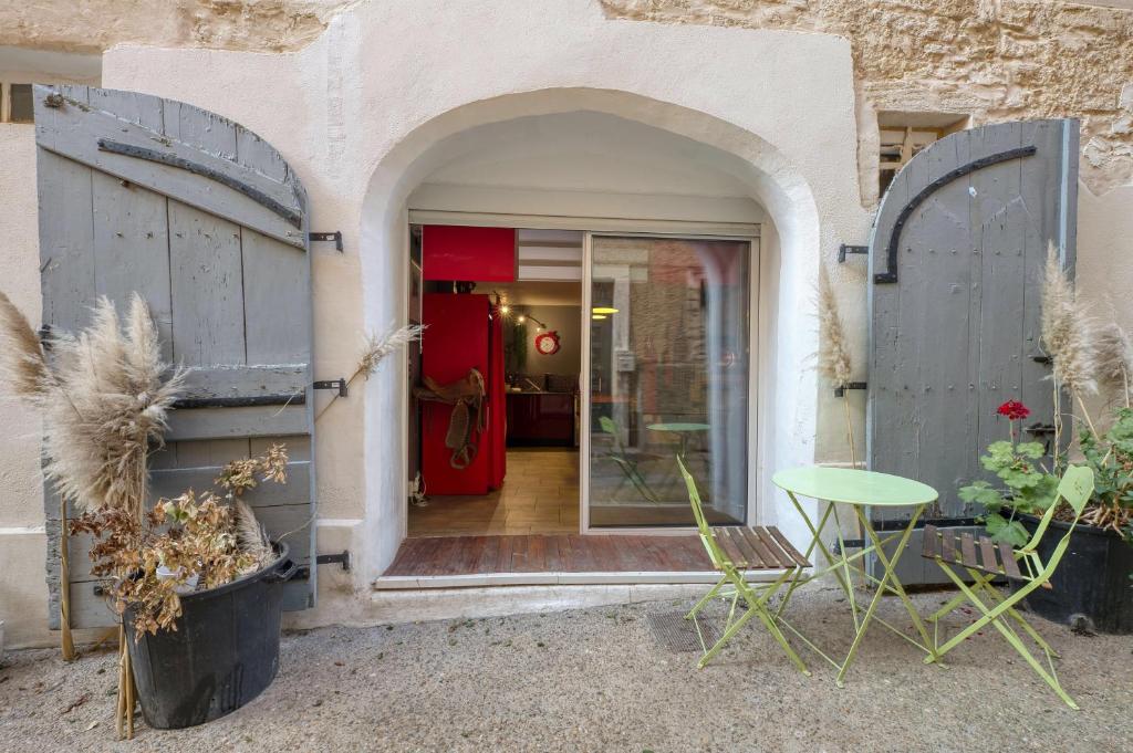 une entrée de maison avec des portes et une table dans l'établissement Studio NEW YORK, à Alignan-du-Vent