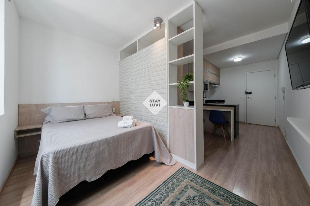 a small bedroom with a bed and a desk at Studio completo em Barueri - Selenita #8 in Barueri