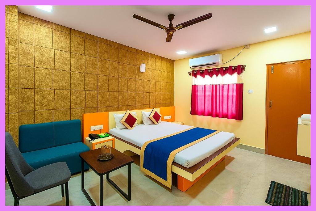 ein Schlafzimmer mit einem Bett und einem Stuhl in einem Zimmer in der Unterkunft Hotel Coral Premium Suite Near Jagannath Temple - Sea Beach - Lift Free Parking & Swimming Pool - Best Prime Location Hotel in Puri