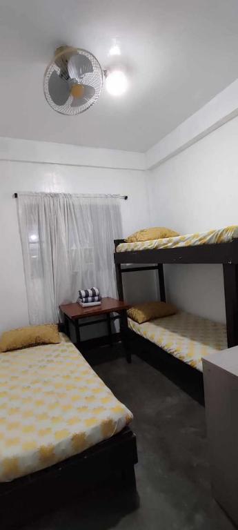 a room with three bunk beds and a table at Ma Fremie's Hometel in Lal-lo