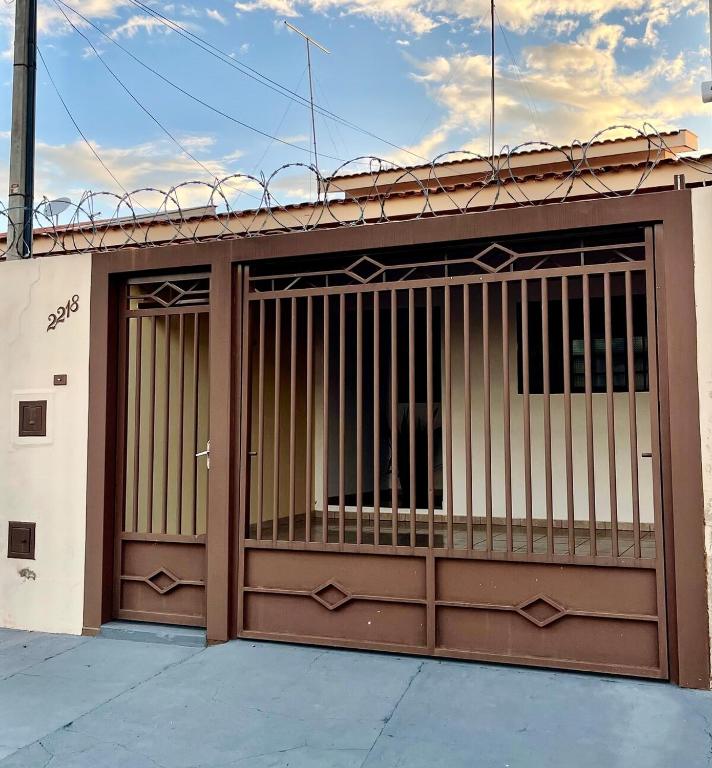 a building with a garage door with bars on it at Casa Gêmeas 2 in Andradina