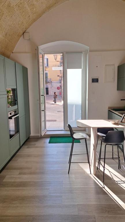 una stanza con tavolo, sedie e cucina di Il porto è di casa a Trani