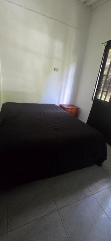 a black bed in a room with a window at Hacienda Popalito in San Rafael