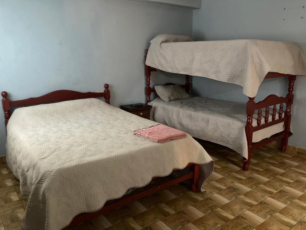 una camera da letto con due letti a castello e un letto più piccolo di Hostal las Margaritas a Salta
