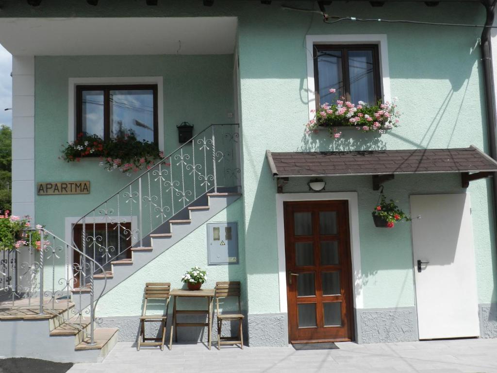 a building with a table and chairs and a staircase at Apartment Kenda in Bovec