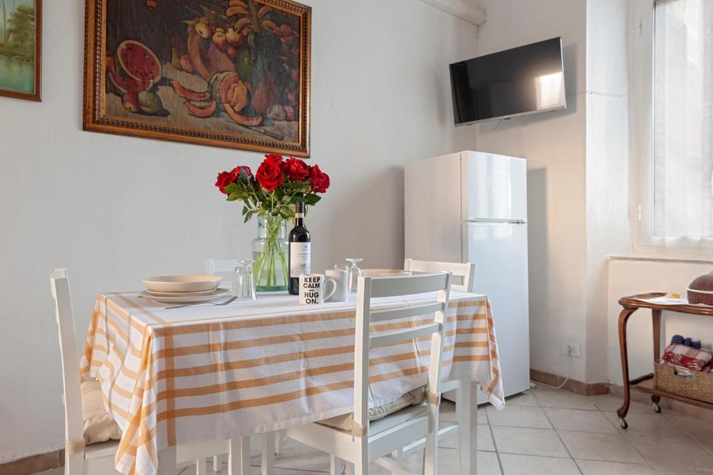una cucina con un tavolo con un vaso di fiori sopra di Seaside holiday inn - free parking a Livorno