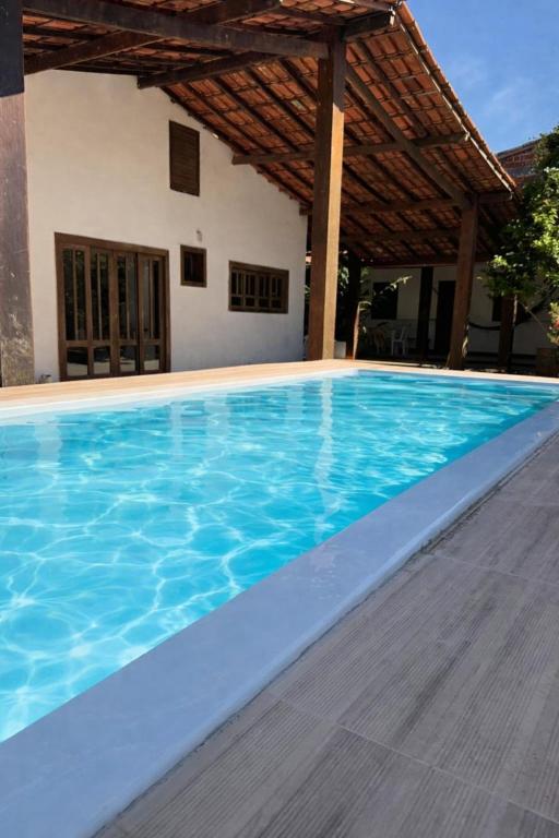 a large blue swimming pool in front of a house at Residência Encantos do Mar in Itacaré