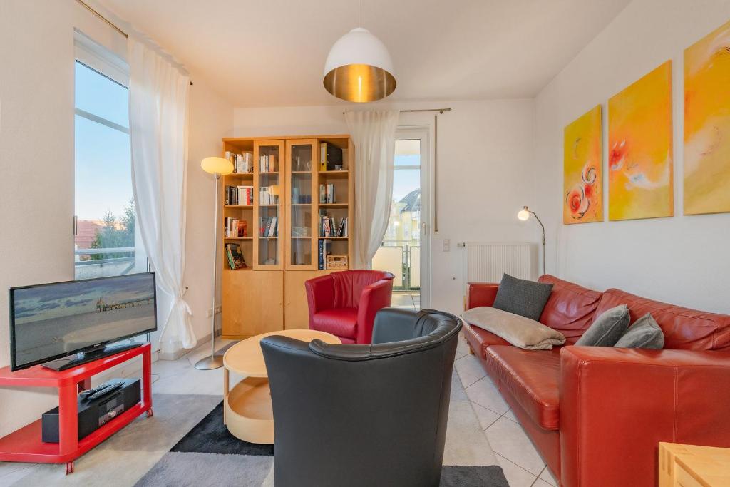 a living room with a couch and a tv at Haus Dünenwald 17 in Zinnowitz