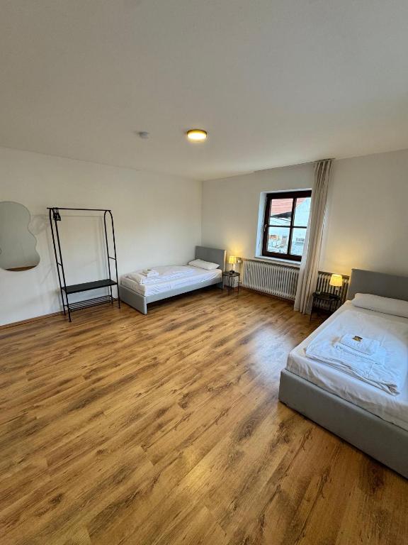 a room with two beds and a wooden floor at Bavaria Home Apartments in Rohrbach
