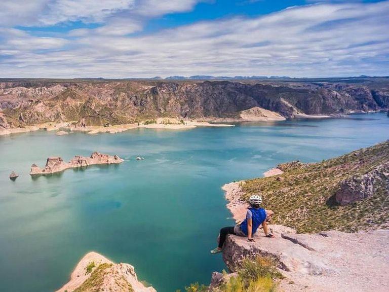 una persona seduta in cima a una montagna che domina uno specchio d'acqua di Centro San Rafael 1 a San Rafael