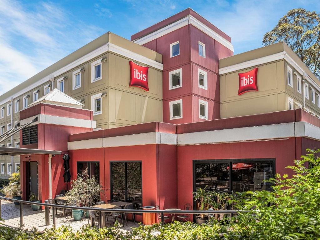 Un gran edificio rojo con un gran cartel. en ibis Thornleigh, en Thornleigh
