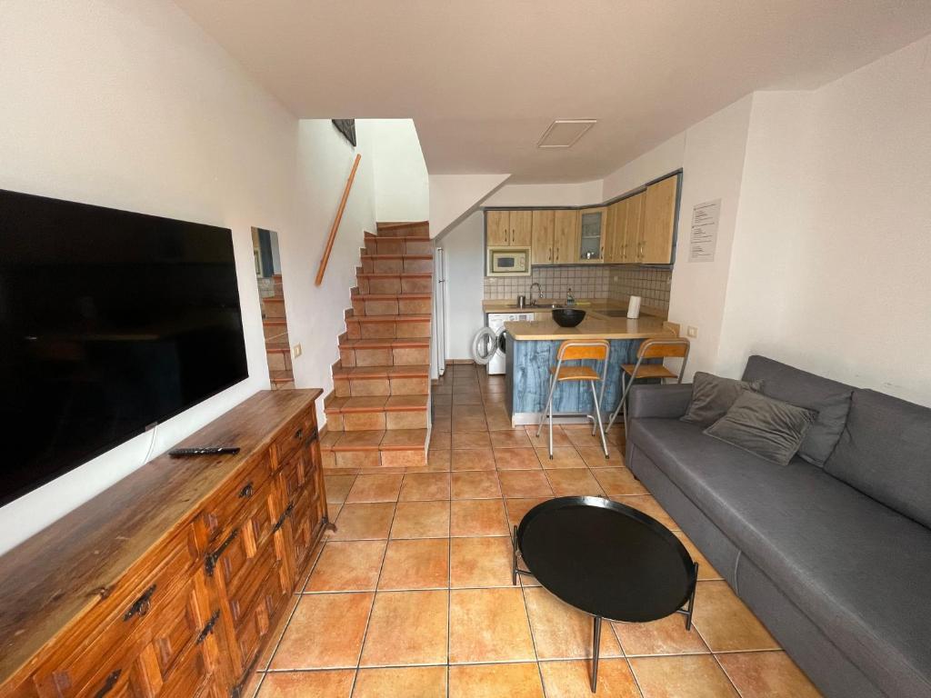 un soggiorno con divano e TV a schermo piatto di Olivia’s house a Maspalomas