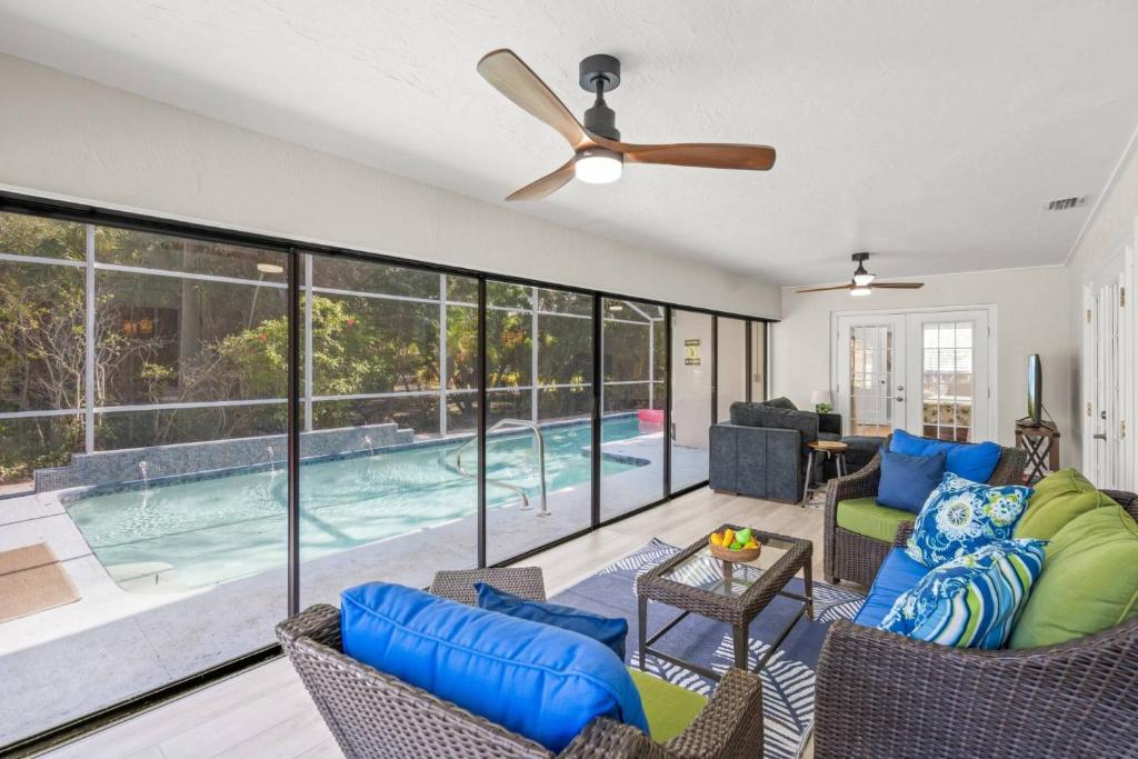 a living room with a pool and a ceiling fan at Toes in the Water - Pool Home on Siesta Key in Siesta Key