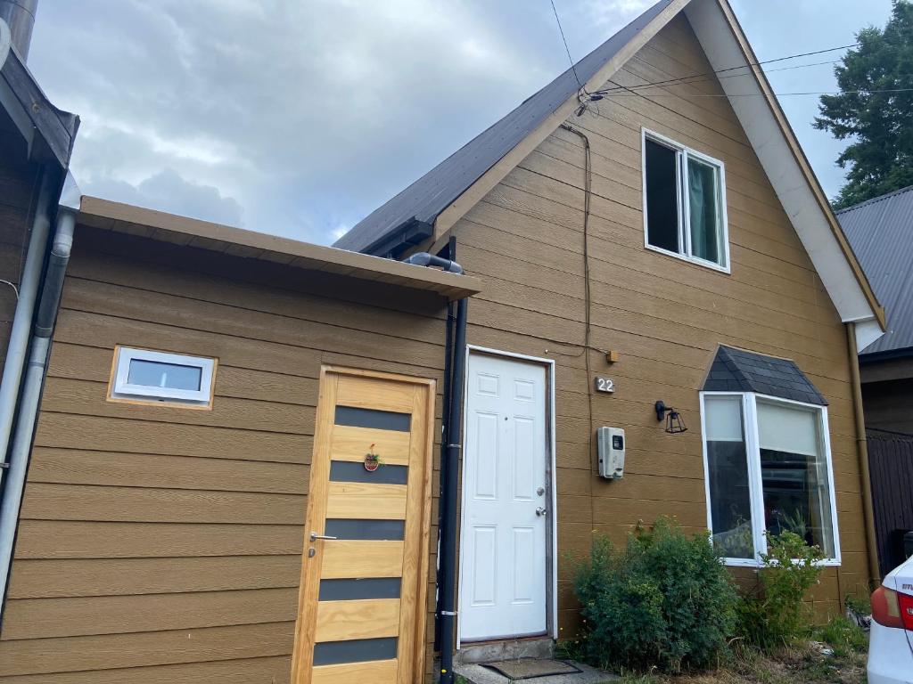un garage marrone con una porta bianca e una casa di Refugio urbano a Villarrica