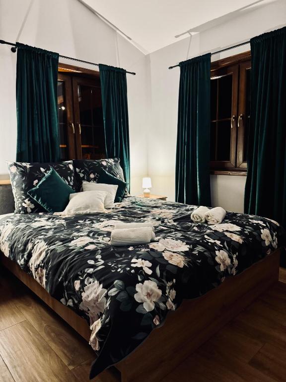 ein Schlafzimmer mit einem Bett mit einer schwarz-weißen Bettdecke in der Unterkunft Pstrągowo - domki z jacuzzi in Machowa
