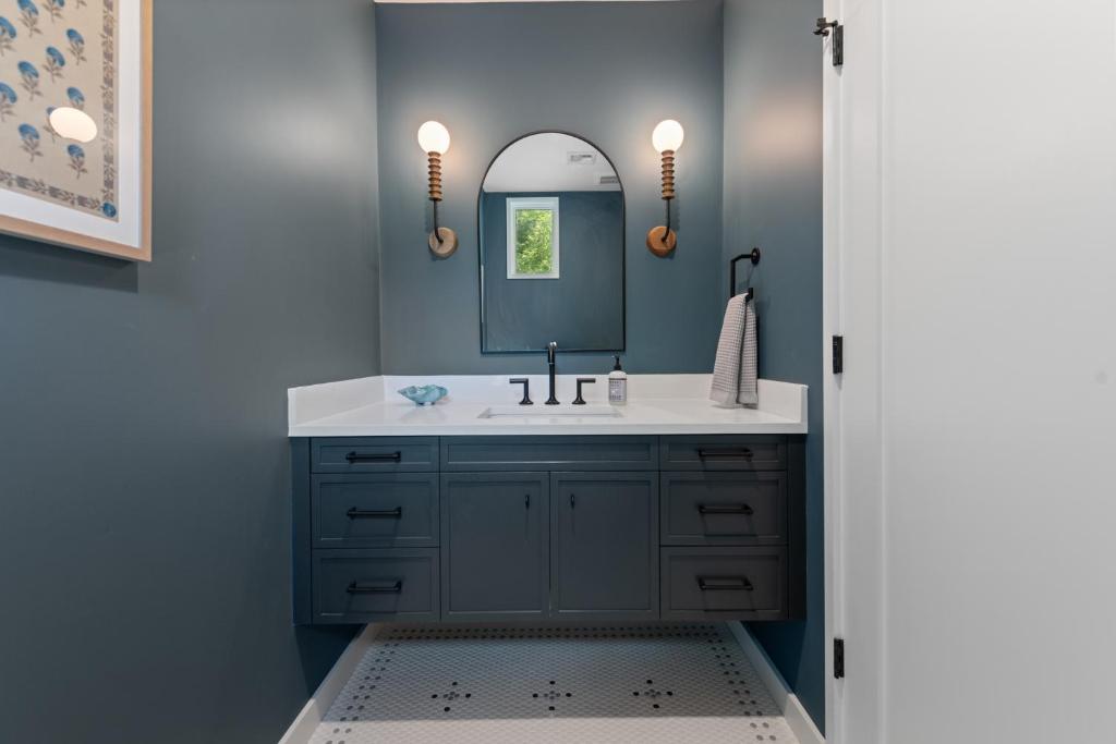 een badkamer met een wastafel en een spiegel bij NEW! Tilted Pine - Lake Access Modern Home in Center Harbor