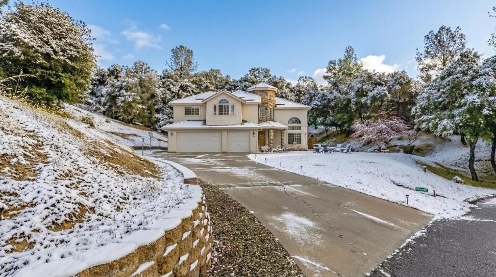 ein Haus auf einem schneebedeckten Hügel mit einer Auffahrt in der Unterkunft Heaven Heights - HotTub, Pet Friendly, EV Outlet, Pool Table, Game Room, BBQ, FirePit, Library in Oakhurst