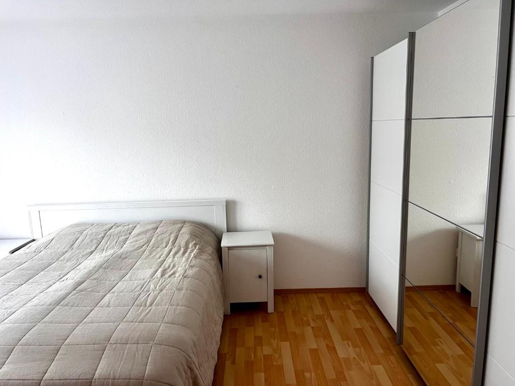 een witte slaapkamer met een bed en een ladekast bij City Appartment Neuss in Neuss