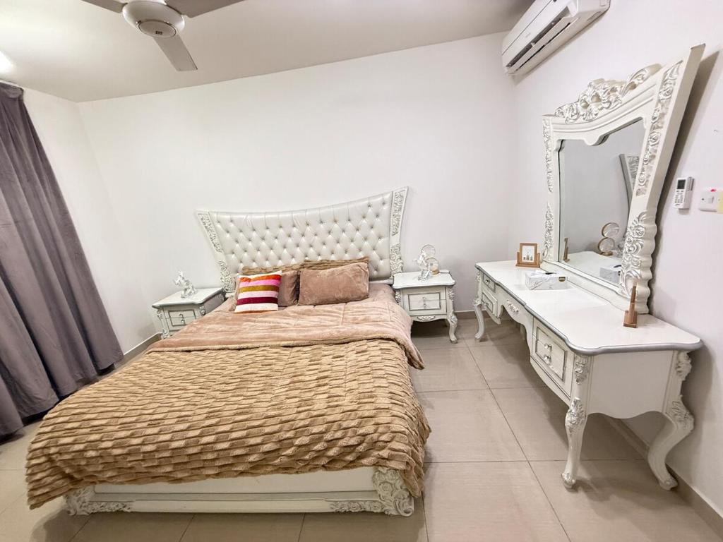 a bedroom with a bed and a vanity and a mirror at Opera67 Spacious & Central in Ghubrah