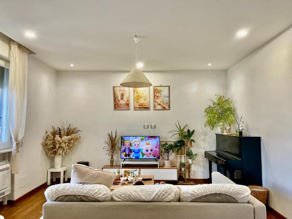 een woonkamer met een bank en een piano bij Happy Nest Tuscany in Castiglion Fiorentino