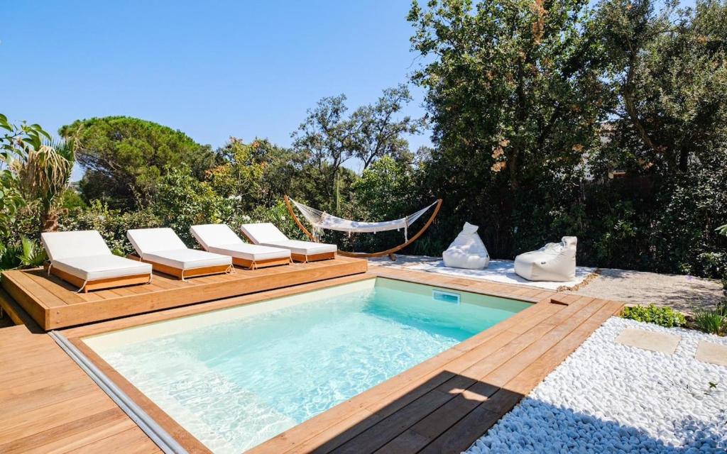 einen Pool mit Liegestühlen und einer Hängematte in der Unterkunft Luxurious new villa pool golf St Tropez in Sainte-Maxime