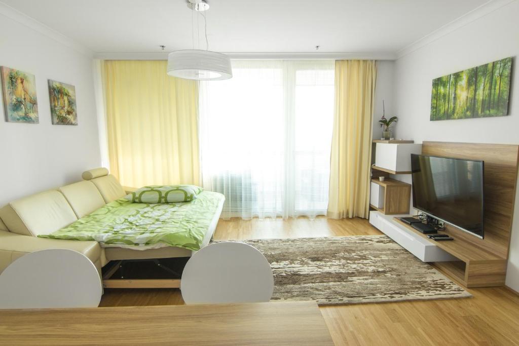 ein Wohnzimmer mit einem Sofa und einem TV in der Unterkunft Vienna Apartments Hauptbahnhof in Wien