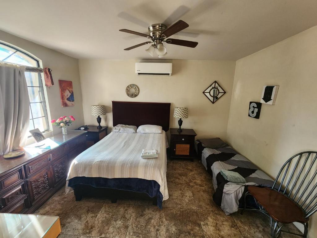 una camera da letto con un letto e un ventilatore a soffitto di Casa Villafontana a Mexicali