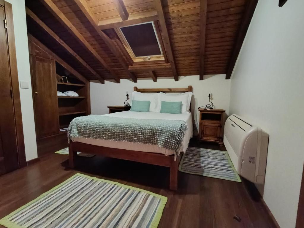 Un dormitorio con una cama y un techo de madera. en Retiro Da Avo Lídia - Turismo Rural, en Mendiga