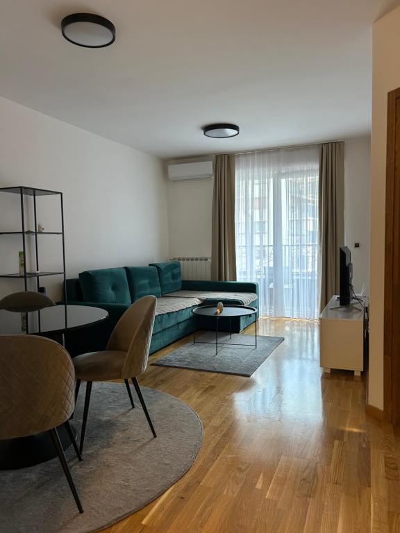 萨拉热窝Lisboa Apartman Bulevar的客厅里有一张绿色的沙发和一张桌子