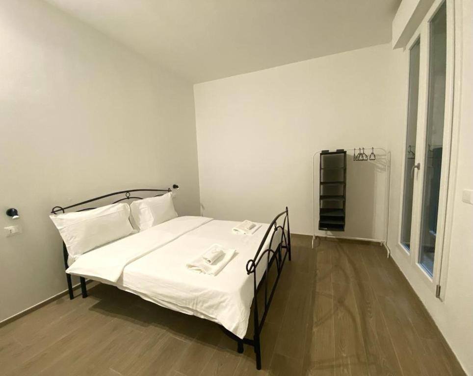 una camera da letto con un letto con lenzuola bianche e cuscini bianchi di ARC Apartments Station a Bologna