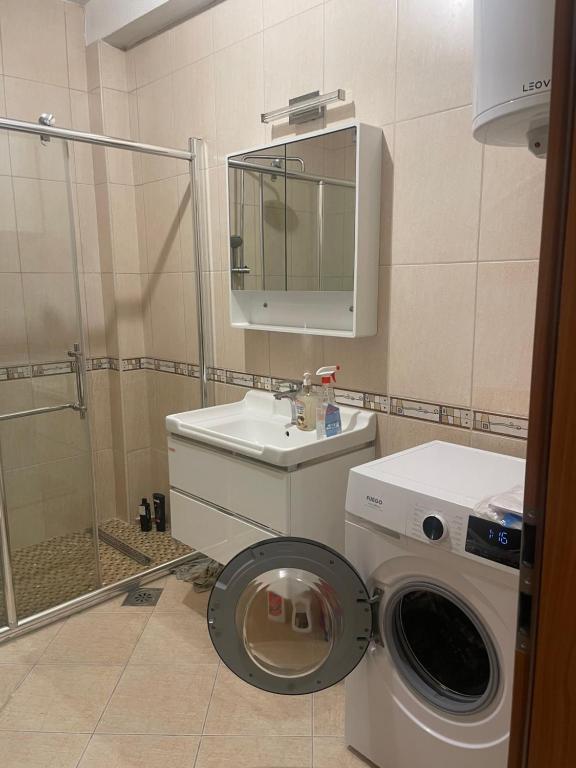 een badkamer met een wasmachine en een wastafel bij FM Apartments ne qender te Pejes in Peje