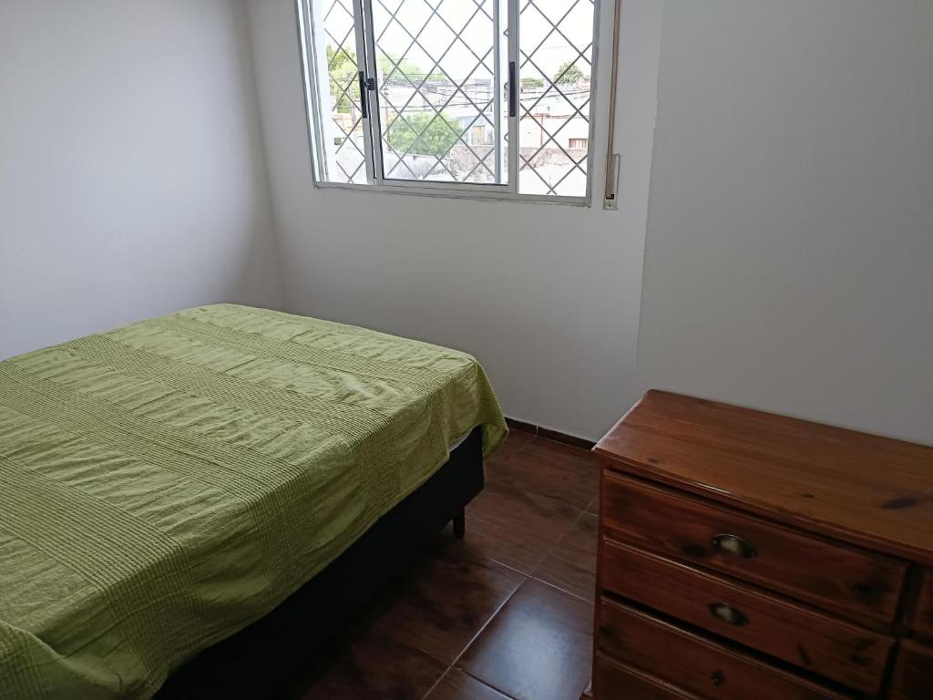 ein Schlafzimmer mit einem Bett, einer Kommode und einem Fenster in der Unterkunft La casita in Minas