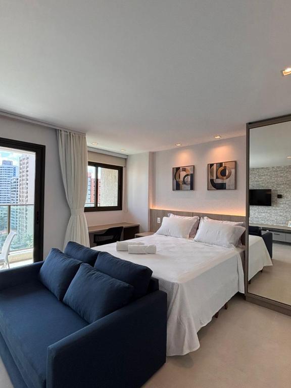 a bedroom with a large bed and a blue couch at Exclusividade e Conforto a 500m da Beira-Mar in Fortaleza