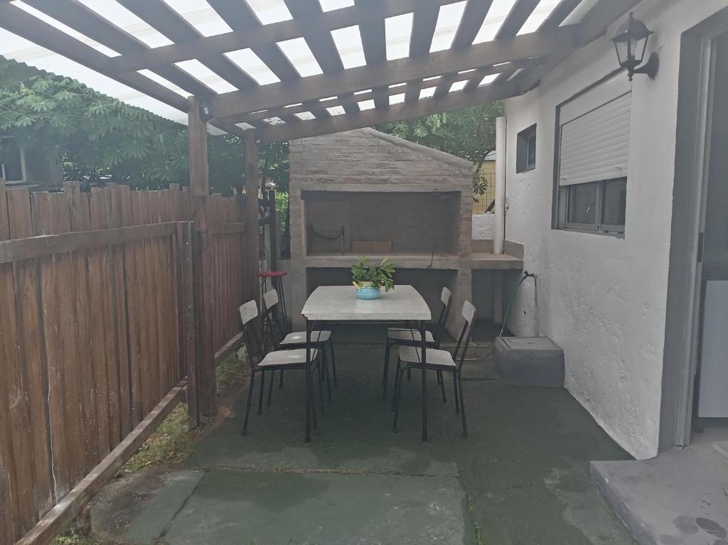 a patio with a table and chairs under a pergola at Casa de verano 2 in Piriápolis